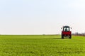 Farmer in tractor fertilizing wheat field at spring with npk Royalty Free Stock Photo