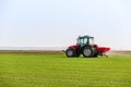 Farmer in tractor fertilizing wheat field at spring with npk Royalty Free Stock Photo