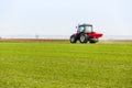 Farmer in tractor fertilizing wheat field at spring with npk Royalty Free Stock Photo