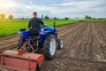 A farmer on a tractor looks at the farmer`s field. Work on the plantation, preparing the soil for subsequent planting