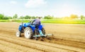 Farmer on a tractor making ridges and mounds rows on a farm field. Marking the area under planting. Soil preparation. Farming