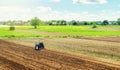 Farmer on a tractor with milling machine loosens, grinds and mixes ground. Cultivating land soil for further planting. Loosening,