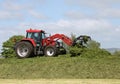 Farmer on tractor packing down silage stack