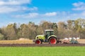 Farmer on tractor plowing sandy soil in spring season