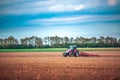 Farmer in tractor preparing land with seedbed cultivator