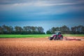 Farmer in tractor preparing land with seedbed cultivator