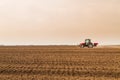 Farmer in tractor preparing land with seedbed cultivator.