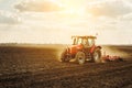 Farmer in tractor preparing land with seedbed cultivator.