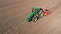 Farmer with tractor with seeder, sowing seeding crops at agricultural field. Aerial view. Royalty Free Stock Photo