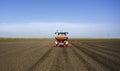 Farmer with tractor seeding crops at field Royalty Free Stock Photo