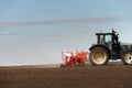 Farmer with tractor seeding crops at field Royalty Free Stock Photo