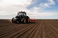 Farmer with tractor seeding crops at field Royalty Free Stock Photo