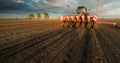 Farmer with tractor seeding - sowing crops at agricultural field