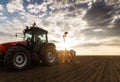 Farmer with tractor seeding - sowing crops at agricultural field