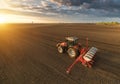 Farmer with tractor seeding - sowing crops at agricultural field Royalty Free Stock Photo