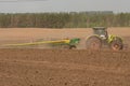 Farmer with tractor seeding - sowing crops at agricultural fields in spring Royalty Free Stock Photo