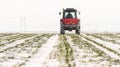 Farmer with tractor seeding - sowing crops at agricultural field Royalty Free Stock Photo