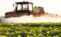 Farmer on a tractor with a sprayer makes fertilizer for young vegetable Royalty Free Stock Photo