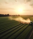 Farmer on a tractor spraying soybean field at sunset. Tractor drives through a green field and sprays crops. Generative AI Royalty Free Stock Photo