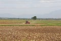 Farmer with tractor and trailer ploughing the field