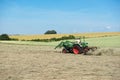 Farmer tractor turns the grass for better drying