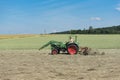 Farmer tractor turns the grass for better drying