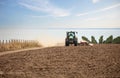 Farmer in tractor working in field on summer day Royalty Free Stock Photo