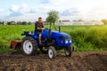 Farmer on a tractor works in the field. Land cultivation. Seasonal worker. Recruiting and hiring employees for work in the farm.