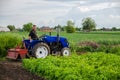 A farmer on a tractor works in the field. Seasonal worker. Recruiting and hiring employees for work in the farm. Milling soil.