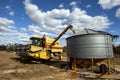 A farmer transfers a load of wheat from his harvester into a field silo. Royalty Free Stock Photo