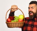 Farmer with tricky face presents apples, grapes and cranberries.