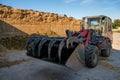 Farmer unloading round bales of straw with a front end loader