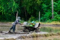 A farmer is using a tractor to plow a rice field filled with water to prepare for next season`s planting