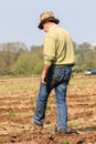 A farmer walking crop field ready to plough at ploughing match