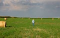 Farmer walking in field with bales Royalty Free Stock Photo