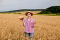 A farmer in a wheat field. Wheat harvest season in Ukraine. Golden ears of corn and a woman holding bread in her hands. Organic Royalty Free Stock Photo