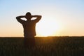 Farmer in wheat field planning harvest activity, female agronomist looking at sunset on the horizon. Royalty Free Stock Photo