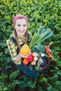 Farmer woman in a field offering organic vegetables