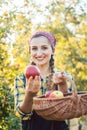 Farmer woman in fruit orchard holding apple in her hands offering Royalty Free Stock Photo