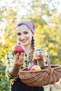 Farmer woman in fruit orchard holding apple in her hands offering Royalty Free Stock Photo