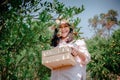 Farmer Woman is Harvesting Oranges Fruit While Holding Wooden Basket With Happy Smiling in Organic Farm. Cheerful Attractive