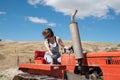 Farmer woman maneuvering a tractor on her farm