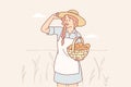 Farmer woman stands in wheat field with spikelets and smiles, holds basket with fresh bread Royalty Free Stock Photo