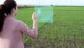 Farmer woman views on a virtual screen data on plant growth and analysis of data obtained on the basis of artificial intelligence.