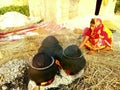 A farmer women with a clay woven processing food grains from paddy by heating.