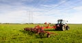 Farmer at work with a hay tedder