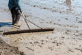 Farmer work on rice field using rake, Rice plantations covered with water.