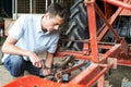Farmer Working On Agricultural Equipment In Barn Royalty Free Stock Photo
