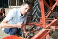 Farmer Working On Agricultural Equipment In Barn Royalty Free Stock Photo