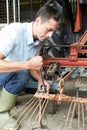 Farmer Working On Agricultural Equipment In Barn Royalty Free Stock Photo